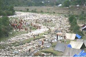 Les marcheurs franchissent le lit de la rivère alors que la police arrive dans le campement. Photo par Tenzin Dasel / Phayul.com 